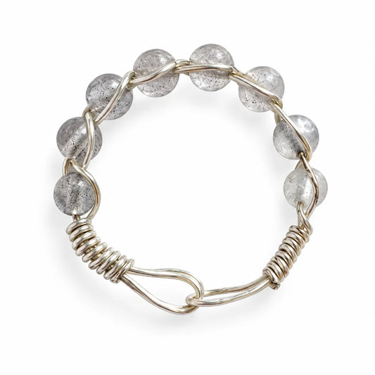 Translucent gray beaded wire-wrapped ring on a white background
